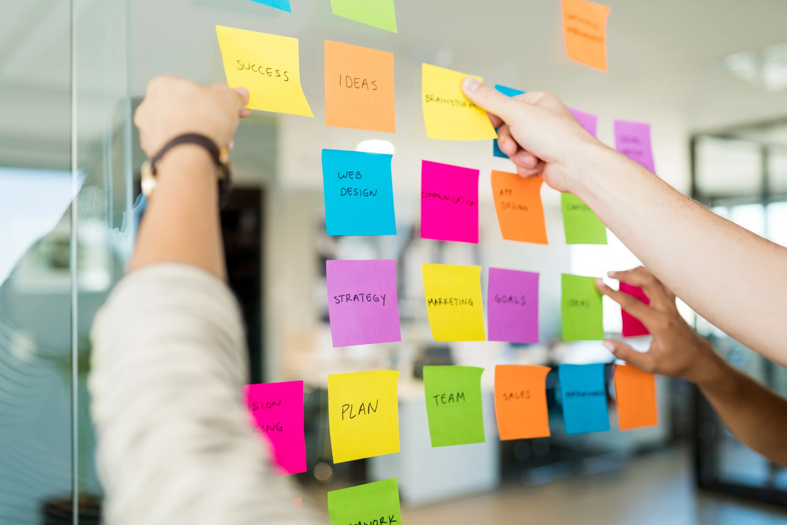 13 strategies to help cope with overwhelm and achieve a more balanced life 3 business people arranging various adhesive notes with text glass officewebp scaled