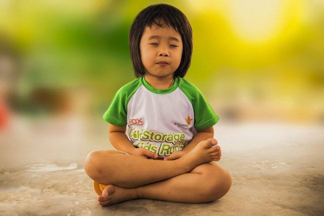 crianca meditando praticando a atencao plena
