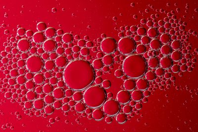 macro photo oil bubbles water surface red background red color water oil