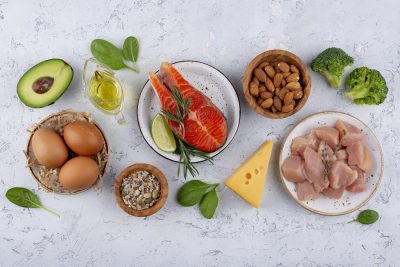 Uma ilustração que mostre diferentes fontes de proteína, como carnes, peixes, ovos, leguminosas, nozes e sementes, com um cérebro humano ao fundo, representando a ideia de que as proteínas são essenciais para a construção e o funcionamento do cérebro.
