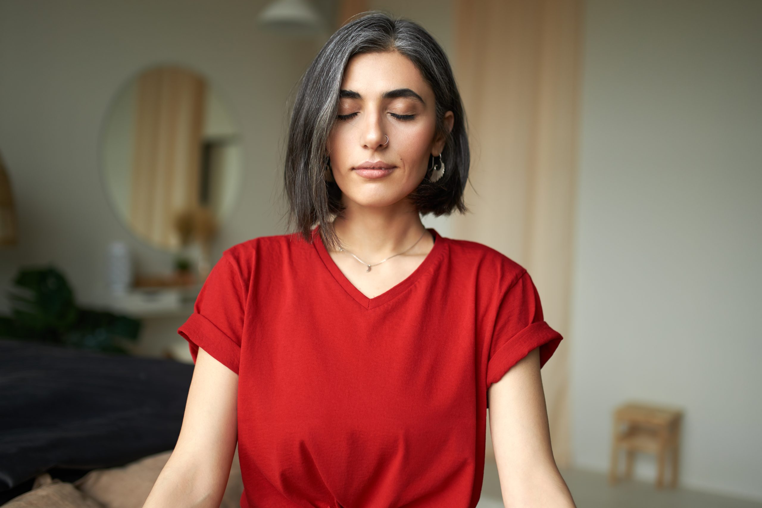 Um Guia Prático para Mulheres com TDAH 2 beautiful young woman with gray hair nose ring meditating indoors using breathing technique scaled