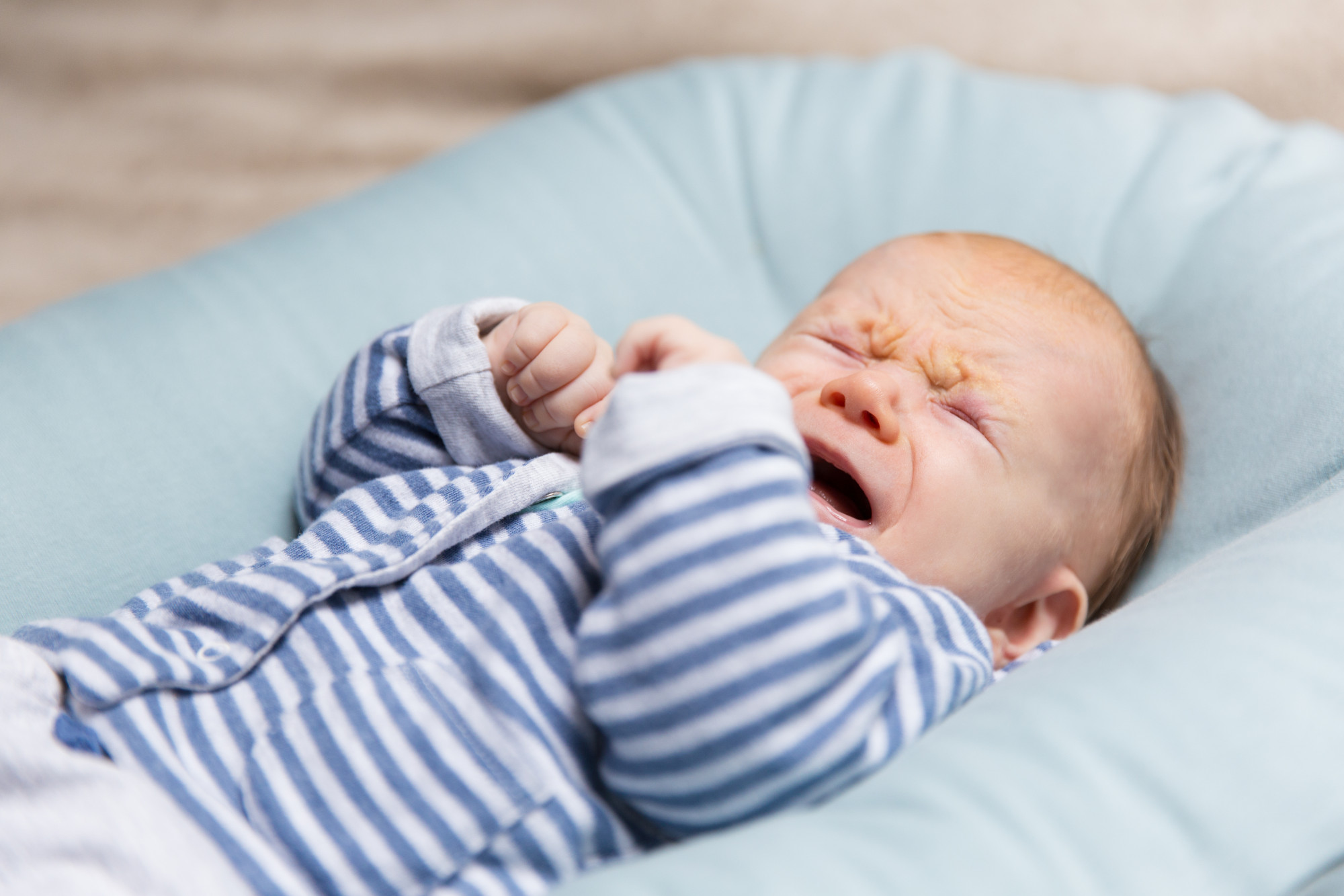 Pode a Amamentação Reduzir o Risco de TDAH? 3 crying red haired baby blue grey clothes
